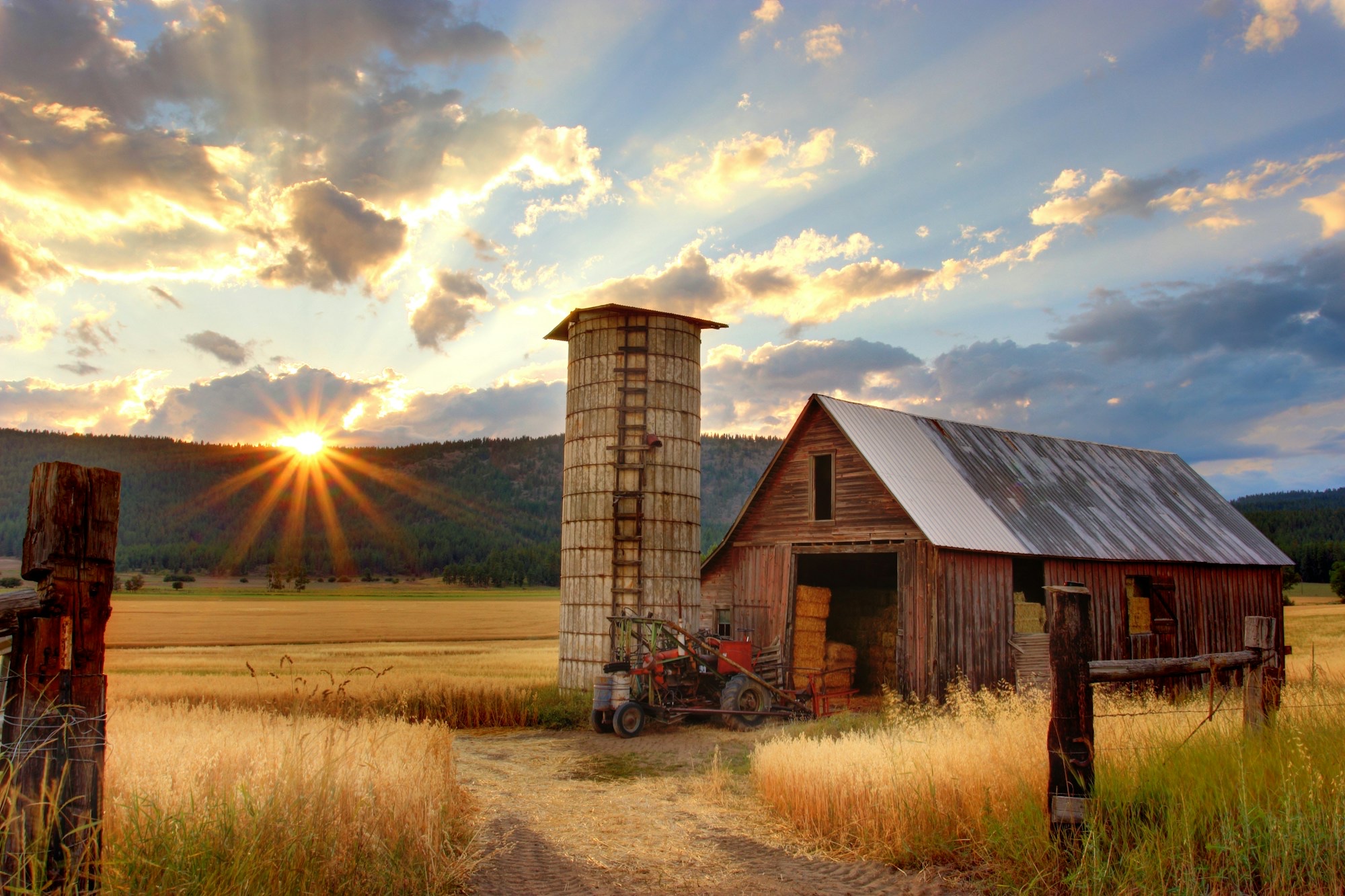 Sunset over a weathered barn and silo at a family farm